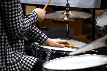 Fototapeta na wymiar Hands of a girl playing a drum set