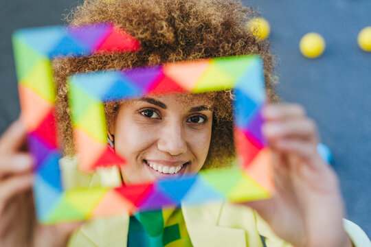 Smiling woman looking through multi colored toy