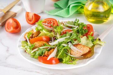 Healthy vegetable green salad with grilled chicken fillet breast, fresh lettuce, tomatoes, onion and balsamic dressing. Spring balanced diet salad on white marble background top view copy space