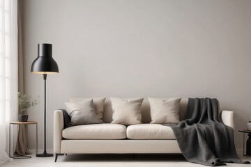 Industrial black lamp next to beige couch with blanket and pillows, copy space on empty white wall