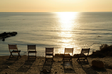Chairs strategically placed along the coast, inviting conversations with the sea