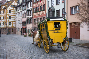 Antigua carroza de correos circulando por las calles del centro histórico de Núremberg, Alemania - obrazy, fototapety, plakaty