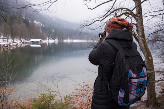 Joven fotografiando el paisaje del lago Alpsee en Füssen, Alemania
