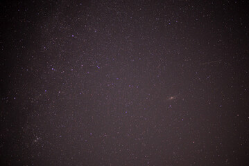 Meteor shower during perseid curent. Andromeda galaxy in the night sky