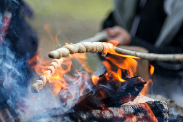 Bread, twisted on a skewer, baked on fire. Stockbrot. Barbecue food, open fire. The children...
