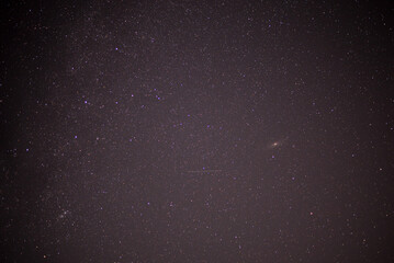 Meteor shower during perseid curent. Andromeda galaxy in the night sky