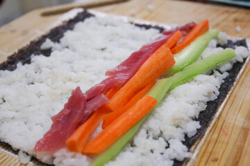 Tuna carrot and cucumber sushi roll preparation
