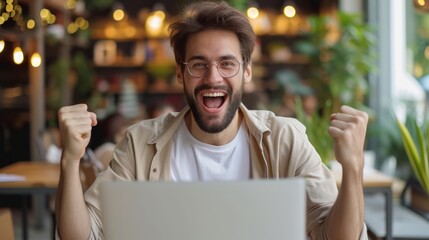 man celebrating victory in front of laptop