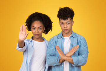 Displeased young African American woman standing with arms crossed