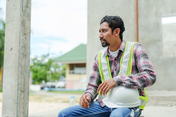 indian man Manager foreman worker engineer housing project building construction project Sitting...