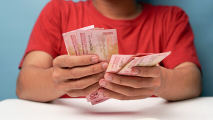a man counts Indonesian rupiah money