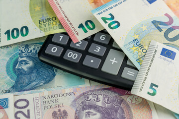 Background made of Polish zloty banknotes, calculator and euro banknotes