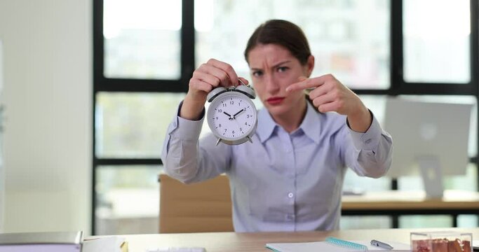 Strict woman manager or boss holding an alarm clock