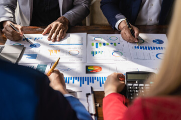 Teamwork with business people analyzing cost graphs on a table at a business conference room and office workers working with project planning documents on a conference table, close-up photography