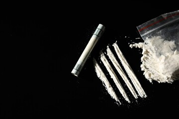 Plastic bag with hard drug and rolled dollar banknote on black background, flat lay. Space for text