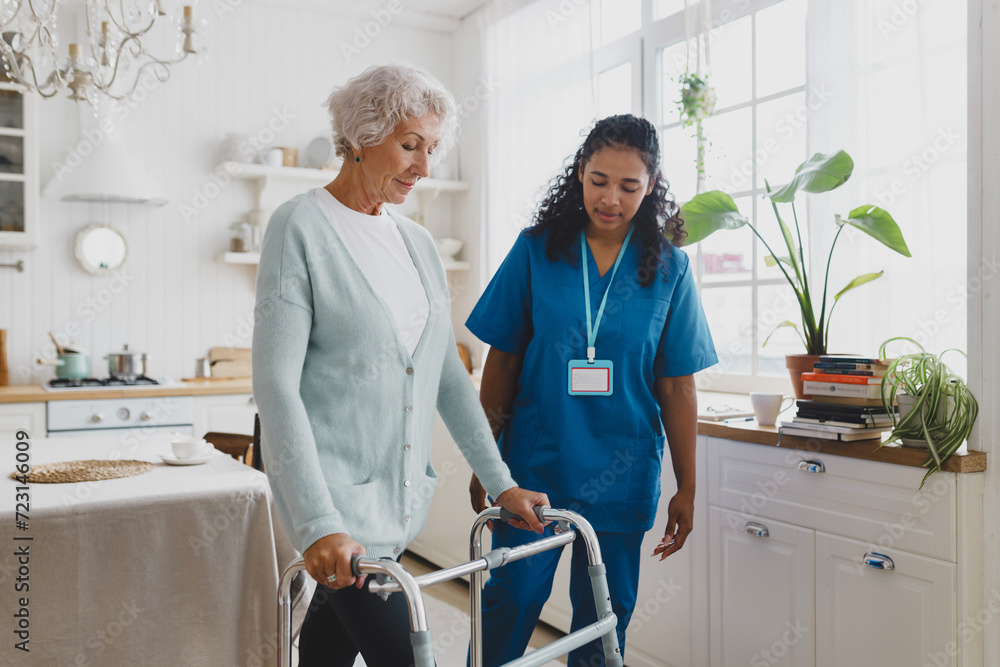 Wall mural side view of black african american nurse volunteer teaching elderly woman with gray hair in cardiga