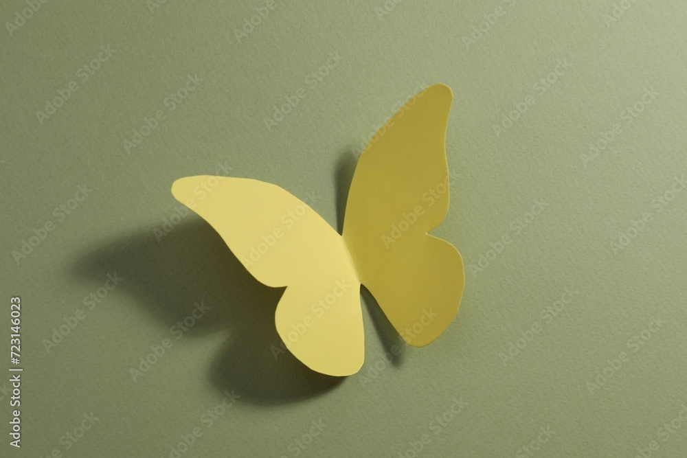 Wall mural Yellow paper butterfly on pale green background, top view