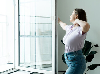Woman Standing By Bedroom Window And Opening Curtains