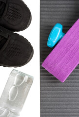Top view yoga mat dumbbeell, shoe, bottle of water and fitness elastic band. Concept sport and healty life.
