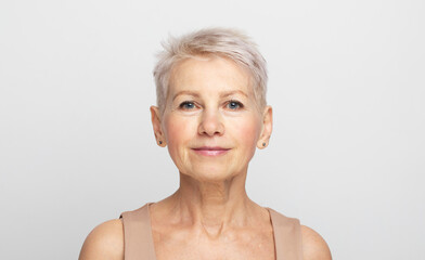 Beauty portrait of mature woman over light grey background
