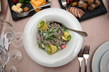 Boiled veal with arugula, tomatoes and cucumbers.