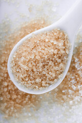 Brown sugar in a teaspoon on white background