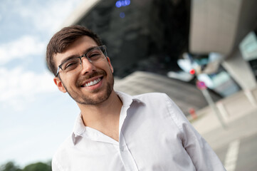 Young dark-haired man in white shirt smiling a d feeling joyful