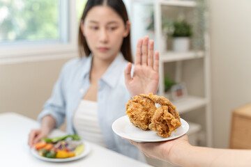 Diet food loss weight concept, Hand of woman pushing fast food away and avoid to eat fried chicken to control cholesterol and sugar.