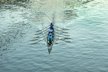 aerial of rower at the river in an five people boat