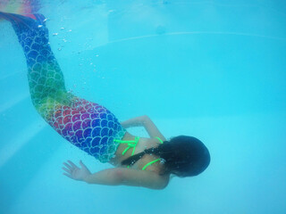 menina criança vestida de sereia em água de piscina no verão 