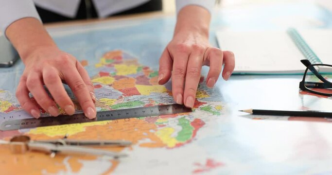 Cartographer with ruler makes measurements on world map - Powered by Adobe