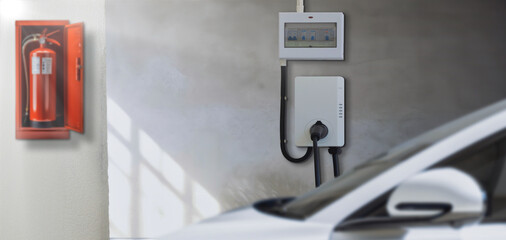 Electric car parking charging at smart house garage wall box charger station stand at family home....