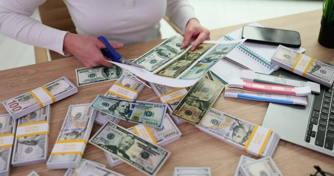 Fraudster cuts out US hundred dollar bills from paper