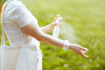 Closeup on female in white shirt using sunscreen