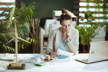 pensive business woman in light business suit in green office - obrazy, fototapety, plakaty
