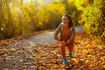 woman in fitness clothes in park stretching