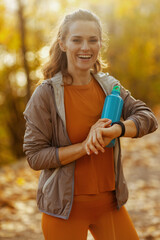 happy woman in fitness clothes in park sport tracker
