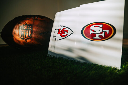 American Football Ball on green Grass and logo of NFL and teams Kansas City Chiefs vs. The San Francisco 49ers. Two Finalists of Super Bowl LVIII in Las Vegas, Nevada