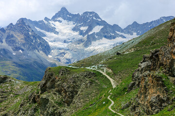 Alpine mountain view with snowy peaks covered with clouds from Rothorn and mountain trail - obrazy, fototapety, plakaty