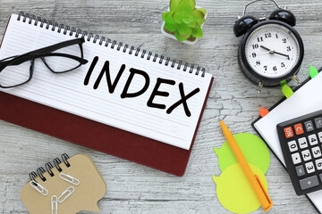 INDEX - glasses lie on an open diary. near the desk clock