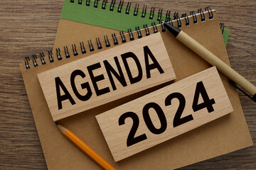AGENDA 2024 text on wooden blocks on a notepad