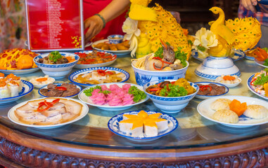 Tet tray. Full of traditional dishes. Chinese new year festival table with asian food. Vietnamese food for Tet holiday in lunar new year. Text on food meaning happy and peaceful.