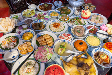 Tet tray. Full of traditional dishes. Chinese new year festival table with asian food. Vietnamese food for Tet holiday in lunar new year. Text on food meaning happy and peaceful. - obrazy, fototapety, plakaty
