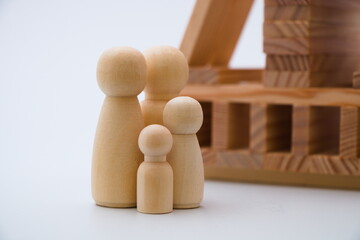 Four wooden figures in front the wooden house