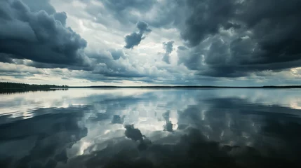 Fotobehang A calm lake reflecting the dramatic clouds of an approaching storm with darkening skies. © Leo
