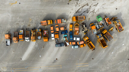 Perpendicular aerial view on orange transport vehicles. They are all work vehicles.