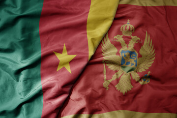 big waving national colorful flag of montenegro and national flag of cameroon .