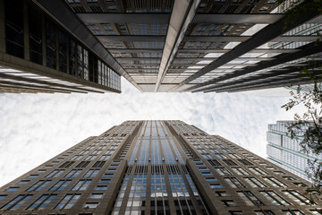 Two skyscrapers almost touching each other above the sky