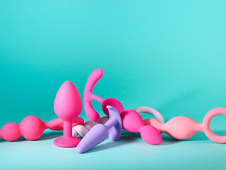Heap of silicone sex toys over turquoise background - obrazy, fototapety, plakaty