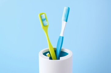 Different toothbrushes in holder on light blue background, closeup